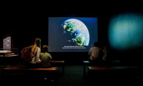 Guests watching introduction video inside exhibition