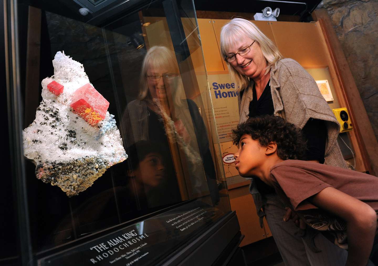 Two people admiring the Alma King, the finest mineral specimen of Rhodochrosite in the world. 