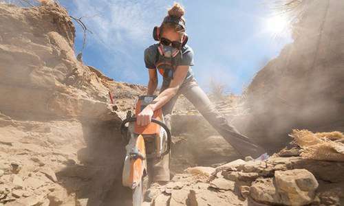 Natalie using a saw in the field