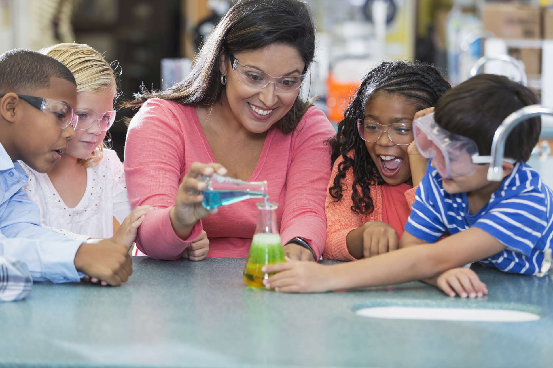 Students and their teacher conduct a chemistry experiment.